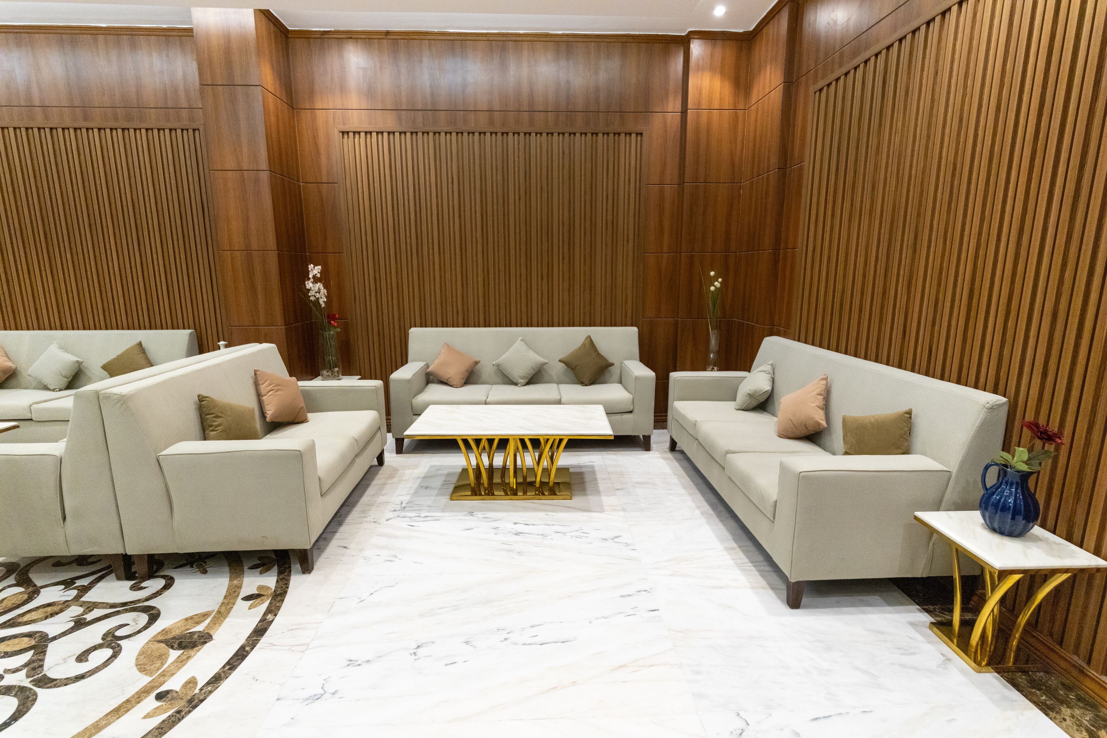 Un salon moderne avec deux canapés, une table basse centrale et une petite table d’appoint.