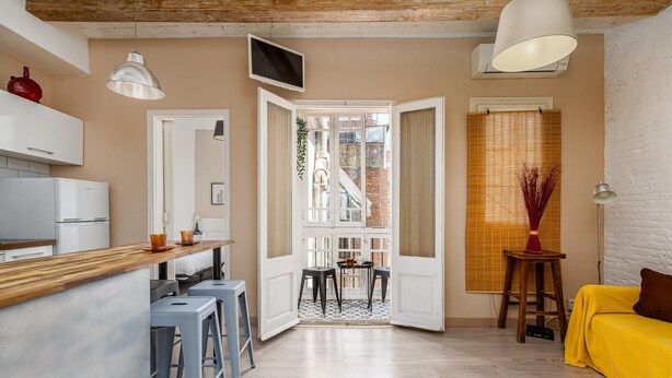 A compact living space with a kitchen, dining area, and a yellow sofa. - Wake in a luminous, chic and ideally located flat, surrounded by the magic of Barcelona (Barcelona)