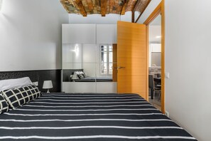 Une chambre à coucher avec un lit, une armoire, un bureau et une chaise.