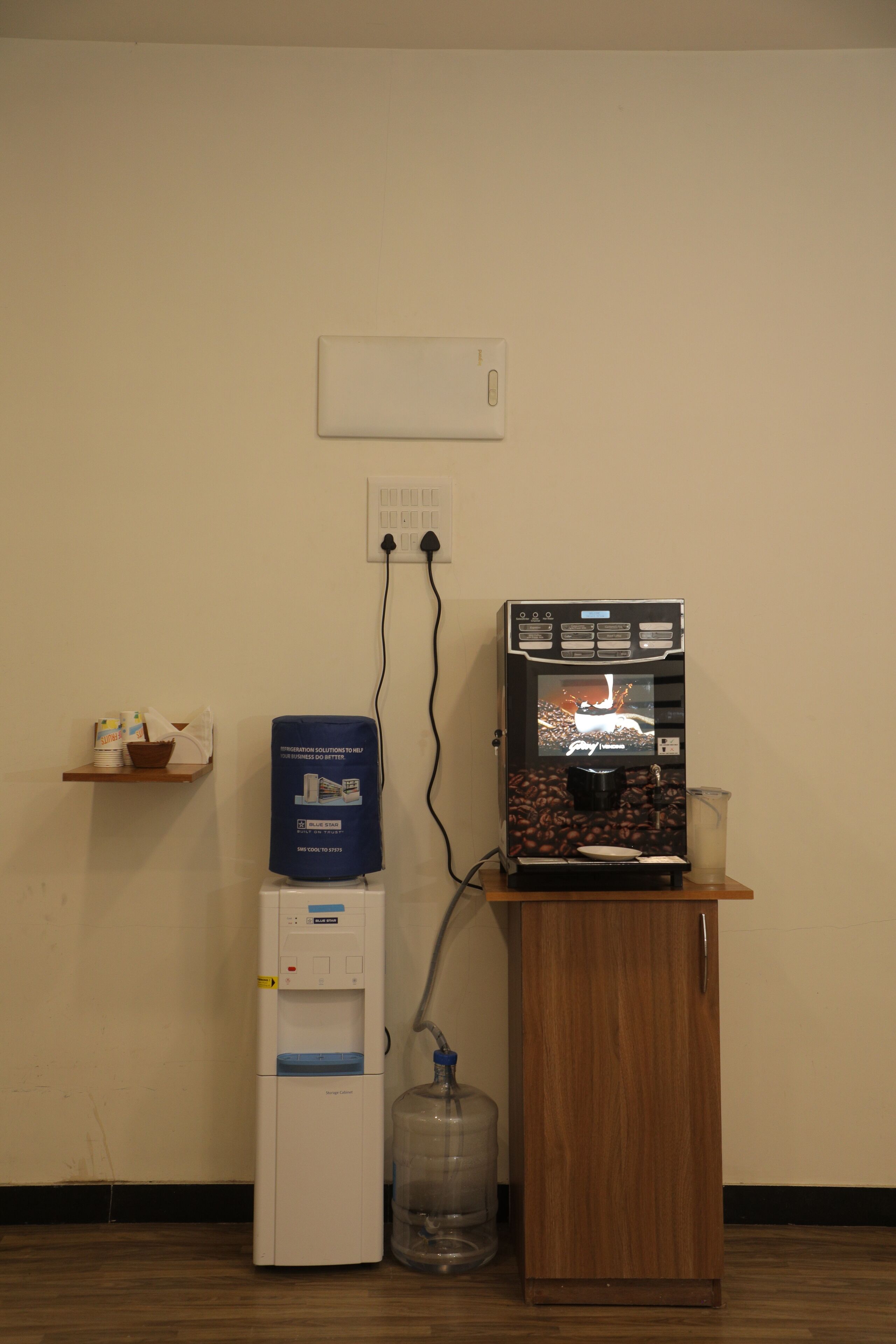 A coffee machine on a wooden counter with a water dispenser and a coffee bean container.