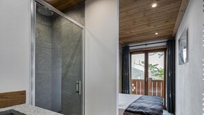 A modern bathroom with a shower, a sink, and a wooden vanity. - Modern duplex for 10 people near slopes in Courchevel Le Praz (Courchevel)