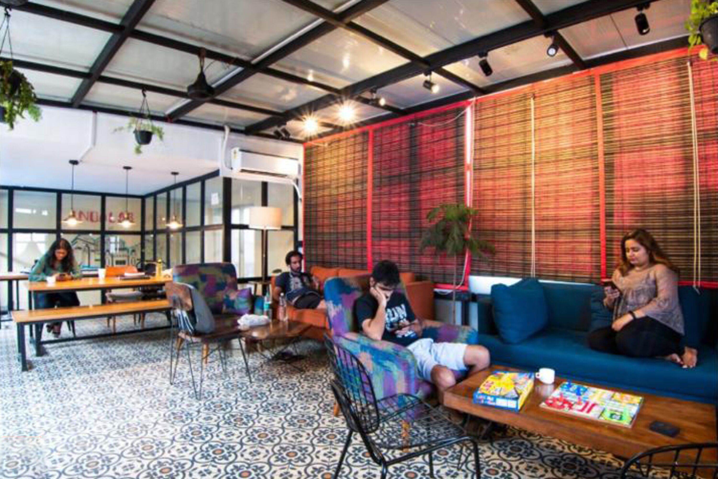 A modern lounge area with seating, tables, and a patterned floor.