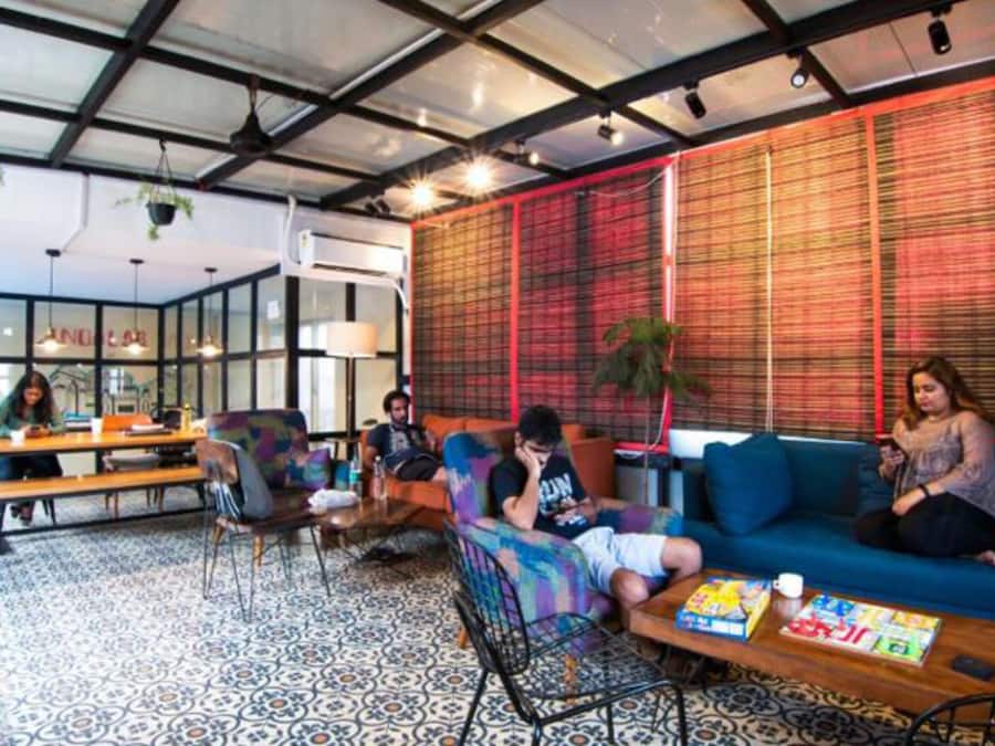 A modern lounge area with seating, tables, and a patterned floor.