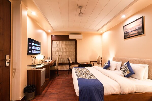 Une chambre d’hôtel équipée d’un lit, d’un bureau, d’une chaise, d’une télévision et d’un appareil de climatisation.