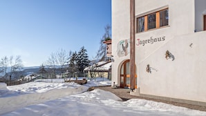 A building with the sign 'Jägerhaus' and a snow-covered landscape.
