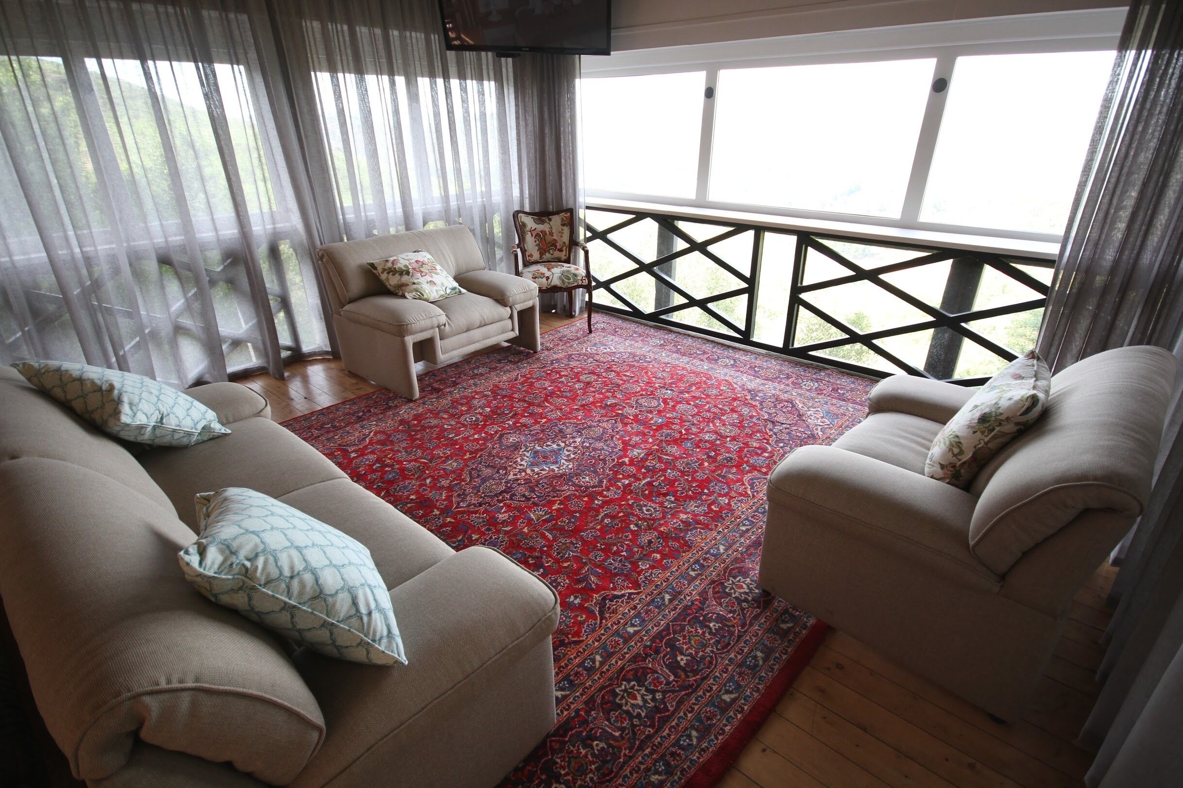 A living room with two sofas, a patterned rug, and a chair.