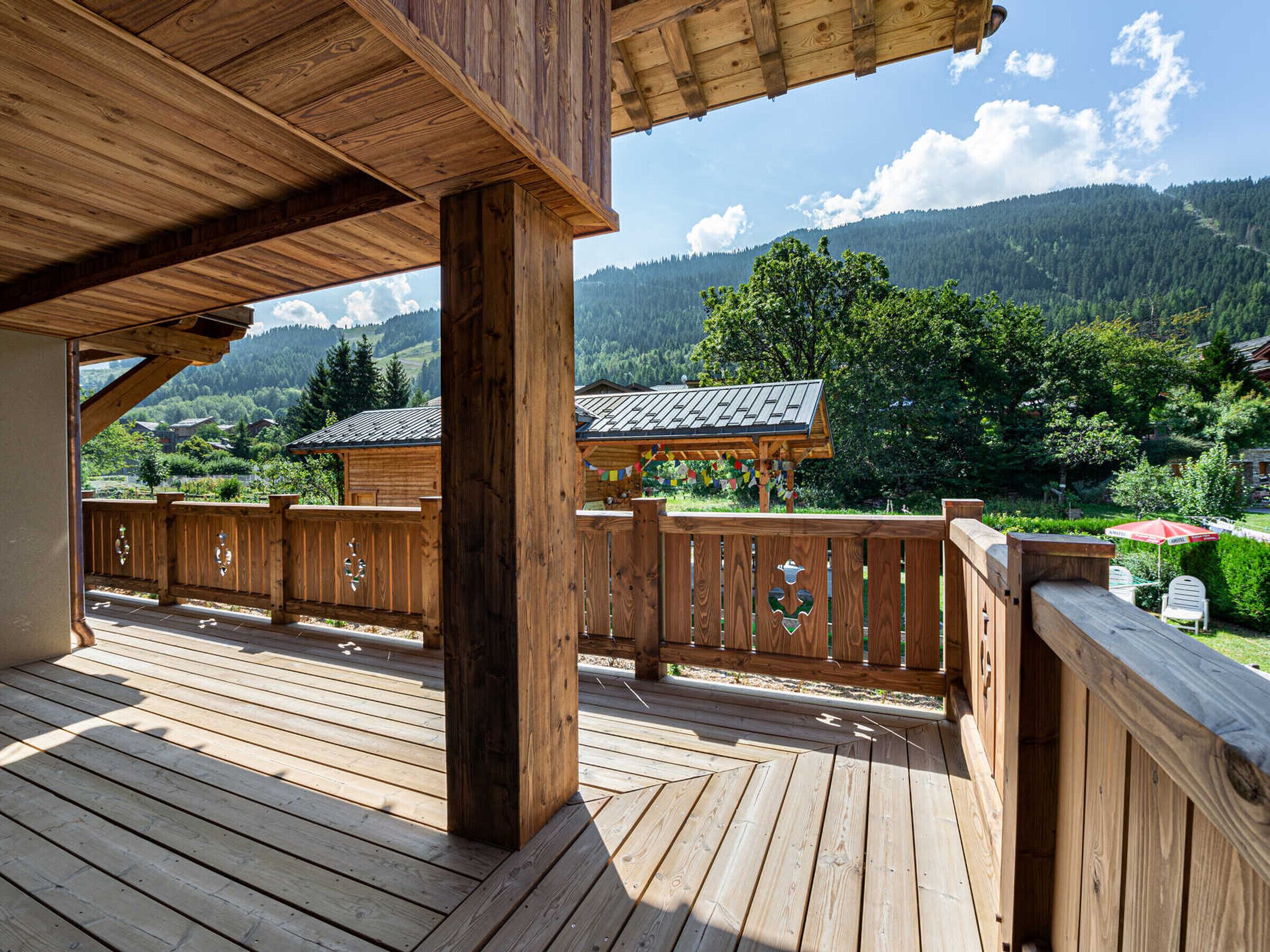 A wooden deck with a view of a mountain landscape.