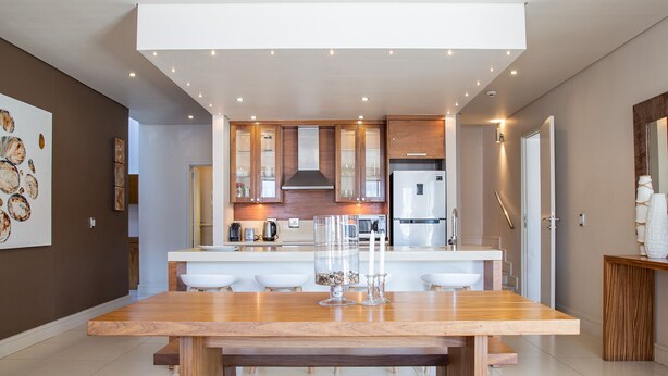 Une cuisine moderne dotée d’un îlot central, de meubles en bois et d’un réfrigérateur en acier inoxydable.