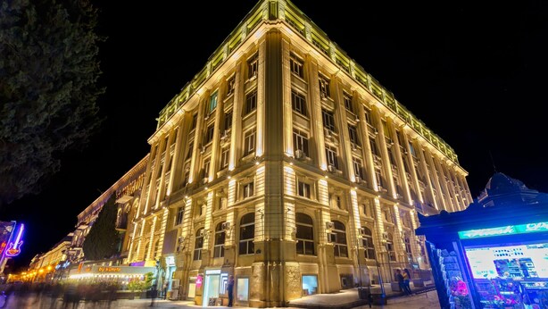 Un grand bâtiment imposant, doté d’une architecture classique, comprenant de nombreux étages et une entrée d’angle particulièrement remarquable.