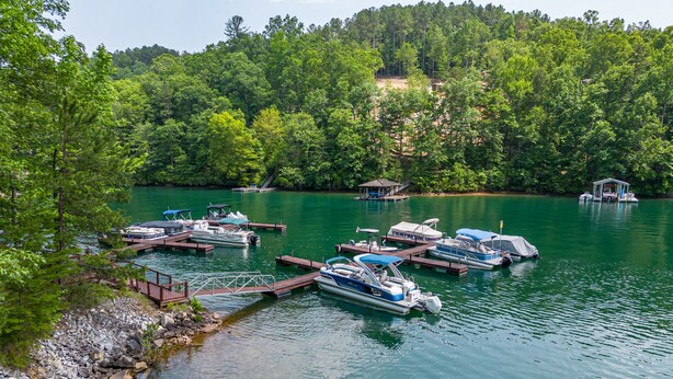 A lakeside dock with several boats and a small pavilion.