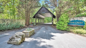A covered walkway leading to a stone wall with a Cedar Creek sign.