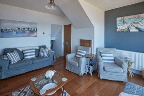 A living room with a sofa, armchairs, a coffee table, and artwork on the walls. - Host & Stay | No 3 Sandside (Whitby)