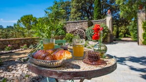 A table with croissants, glasses of tea, and a vase with a red flower. - Bastide Saint-Estève (Brue-Auriac)