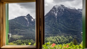 Paisaje montañoso visto a través de una ventana con marco de madera.