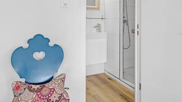 A bathroom with a shower, a sink, and a mirror.