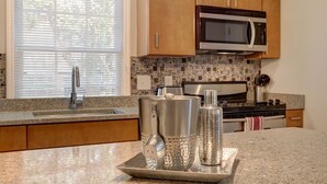A kitchen with granite countertops, stainless steel appliances, and wooden cabinets.