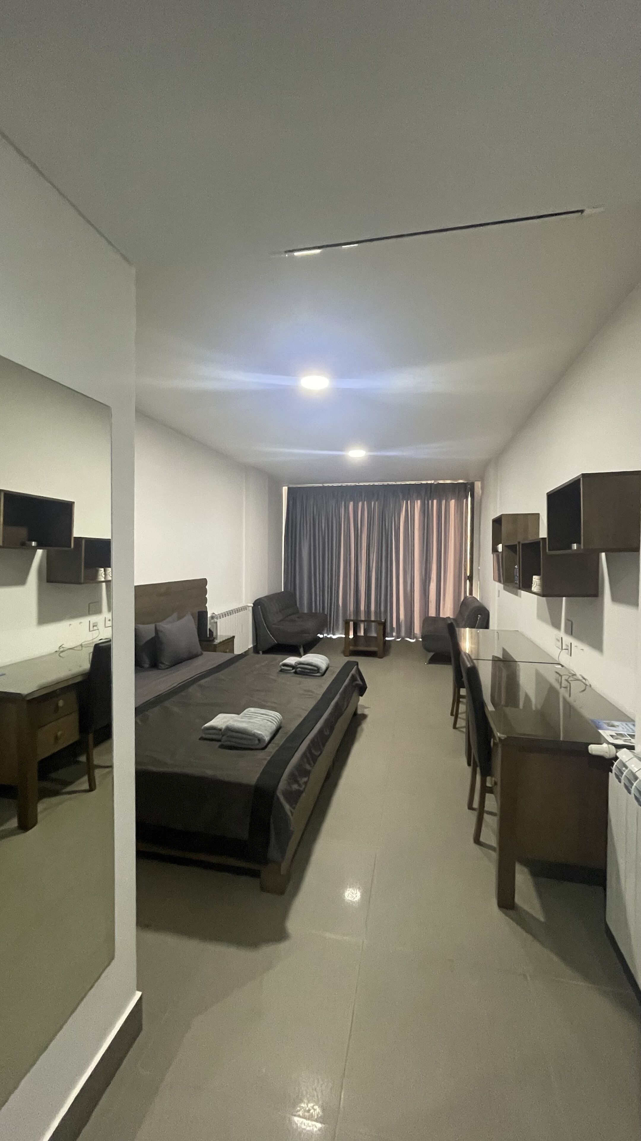 Una habitación de hotel con una cama, un escritorio, una silla y un televisor.