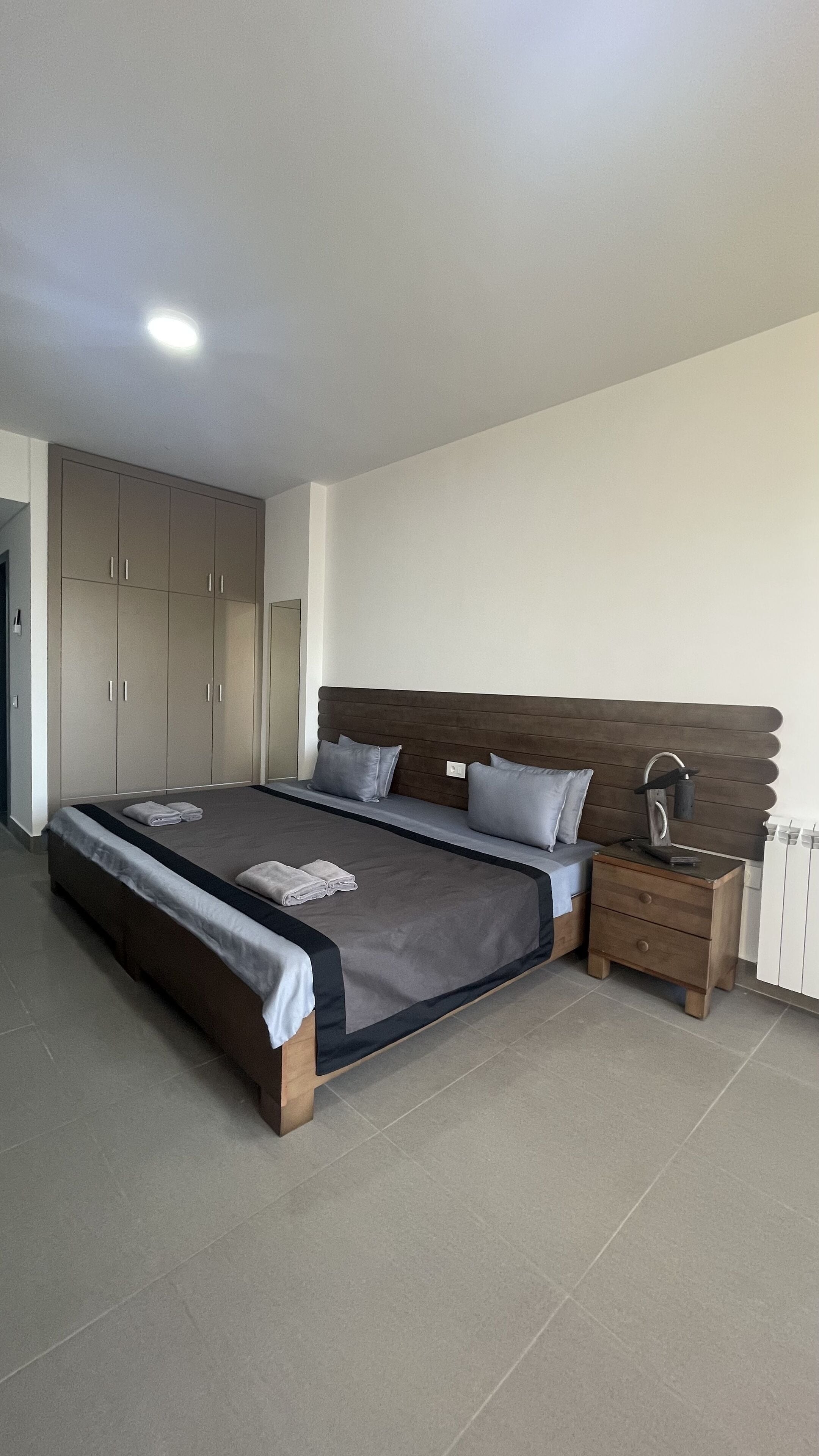 Un dormitorio con cama, mesita de noche y armario.