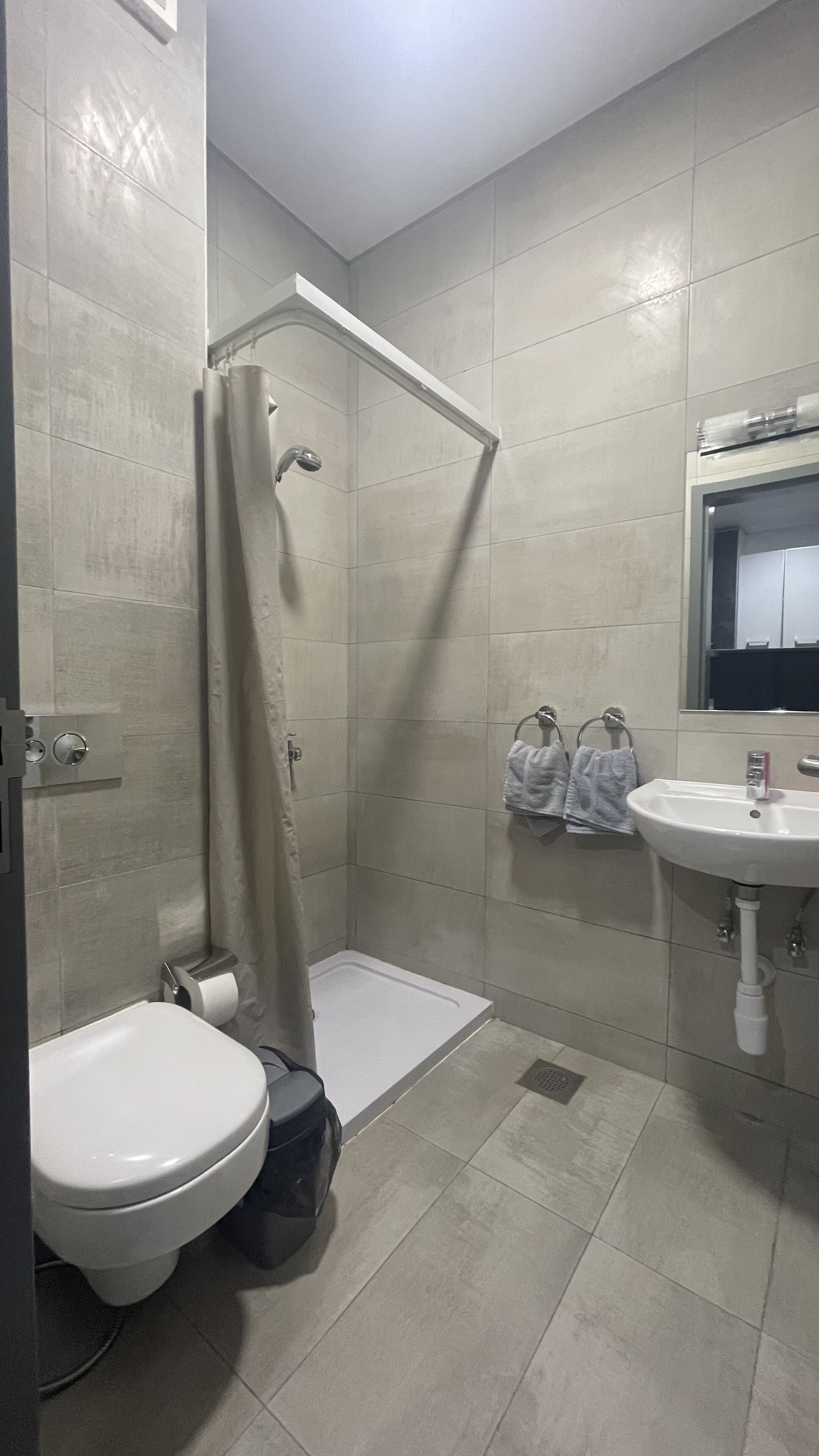 A bathroom with a shower, toilet, and sink.