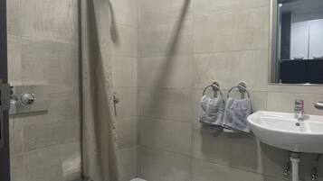 A bathroom with a shower, toilet, and sink.