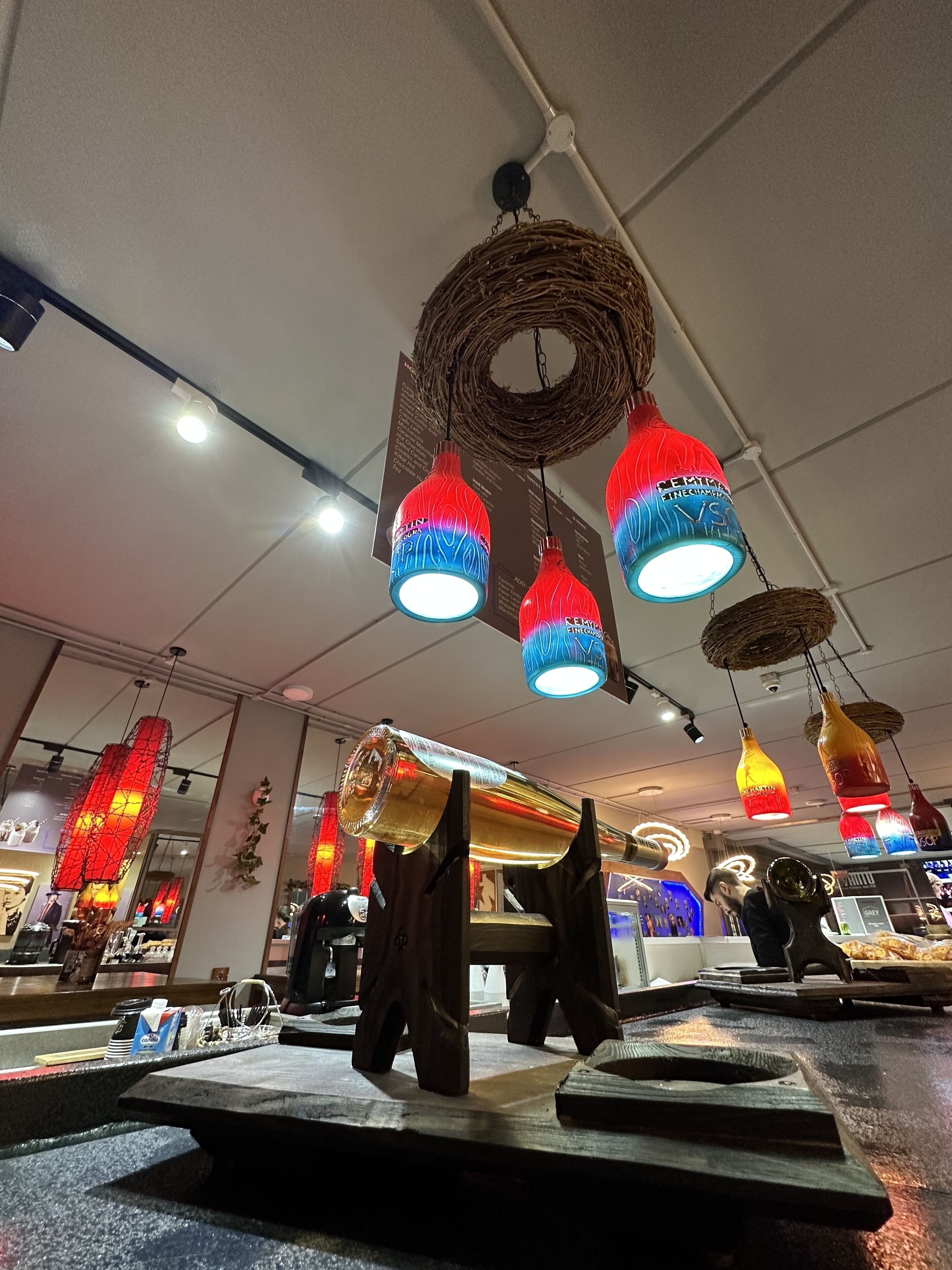 A restaurant interior with hanging decorative lights and a central woven light fixture.