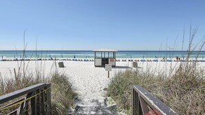 A beach with a wooden boardwalk leading to a beach hut and a sign indicating no tents are allowed. - Family Perfect with Lagoon pool and Crystal Sand Beach! (Panama City Beach)