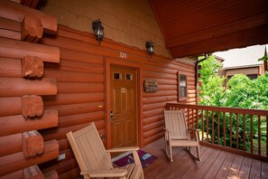 Eine Holzhütte mit Veranda, zwei Stühlen und einer Tür, auf der die Nummer 320 steht.