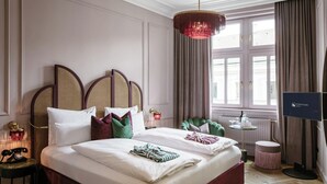 A hotel room with a large bed, a television, a desk, and a window with curtains. - Eurostars Josefine (Vienna)