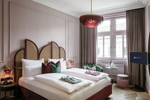 Een hotelkamer met een groot bed, een televisie, een bureau en een raam met gordijnen.