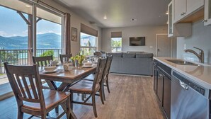 Eine moderne Küche mit Bergblick, ein Essbereich mit Holzkästen und ein großes Fenster.