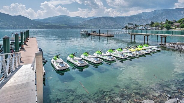A clear lake with a dock and several jet skis lined up. - Majestic Views / Lake Chelan / Pool and Spas! (Manson)