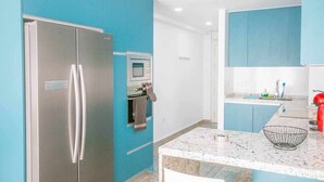 A modern kitchen with a stainless steel refrigerator, built-in oven, and microwave. - Suncastle Lovely Attic! (Alicante/Alacant)
