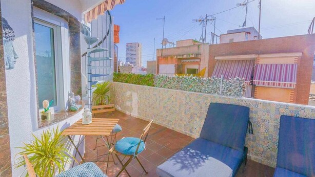 A rooftop terrace with a seating area, including a sofa and chairs, a small table, and potted plants. - Suncastle Lovely Attic! (Alicante/Alacant)