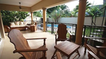 Relax on a classic bench or chair in a tranquil outdoor space overlooking a swimming pool.