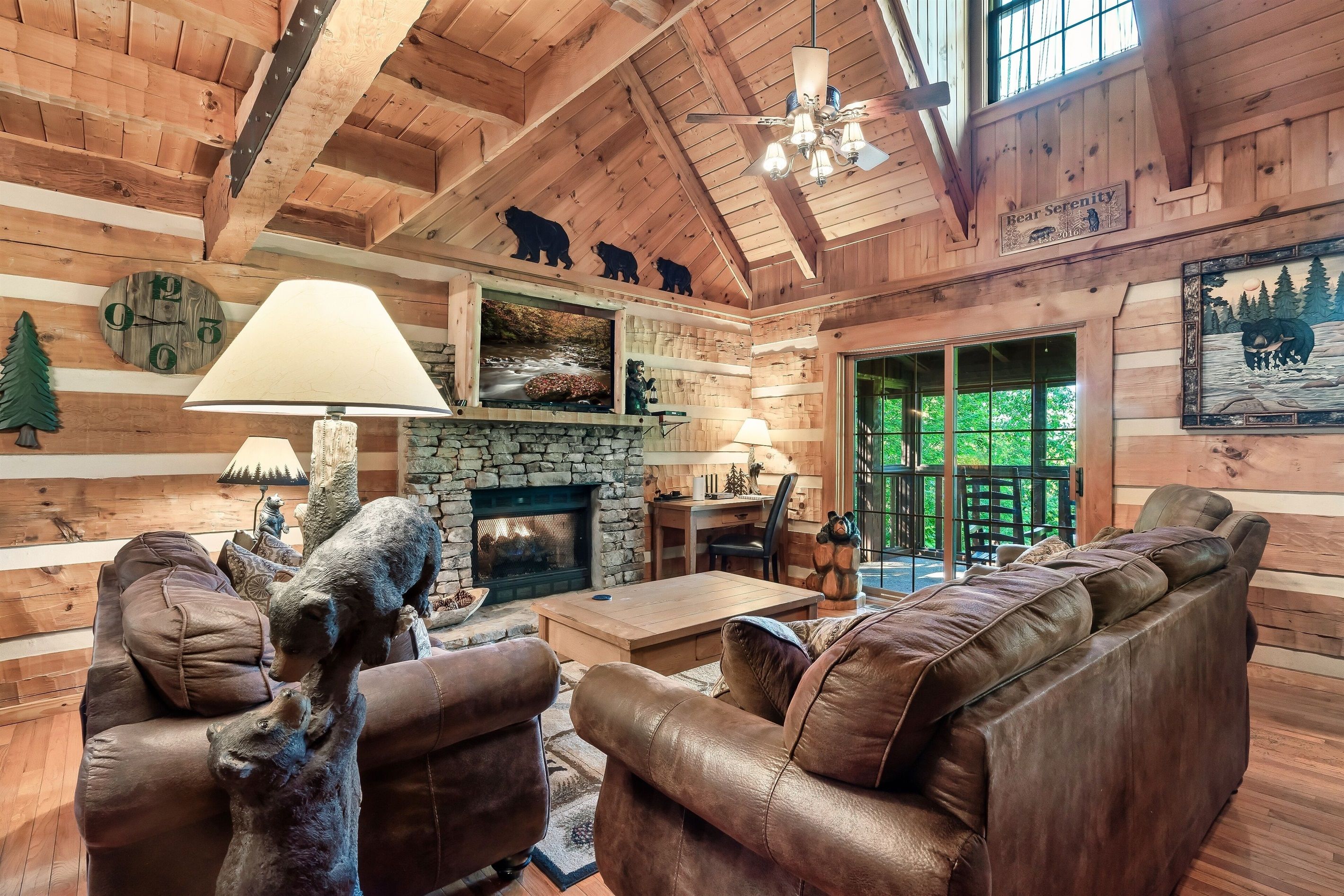 L’intérieur d’une cabane en rondins, avec une cheminée en pierre, des meubles en cuir et une décoration sur le thème des ours.
