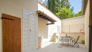 A patio with a wooden door, a white wall, and a table with chairs. - Le Volte by Mmega (Florence)