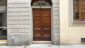 A double wooden door with a small arched window above it, set in a building with a stone facade. - Le Volte by Mmega (Florence)