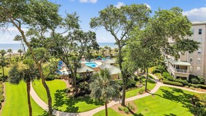 Un resort con piscina, palmeras y vistas al océano.