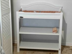 A white metal shelf unit with three shelves, one of which has a folded item on it. - Lakeland Highlands Oasis - 3BR Heated Pool Home (Lakeland)