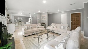 A modern living room with a sofa set, a coffee table, and a fireplace.