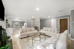 A spacious living room with two sofas, a coffee table, and a fireplace.