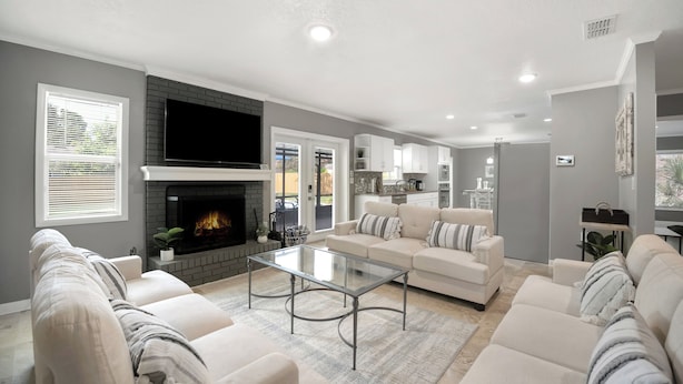 A modern living room with a fireplace, sofas, and a glass coffee table.