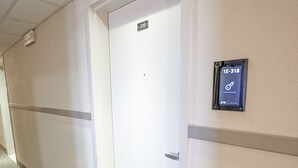 A hallway with a door marked "318" and a digital keycard reader on the wall. - The Armadillo Hotel (Odessa)
