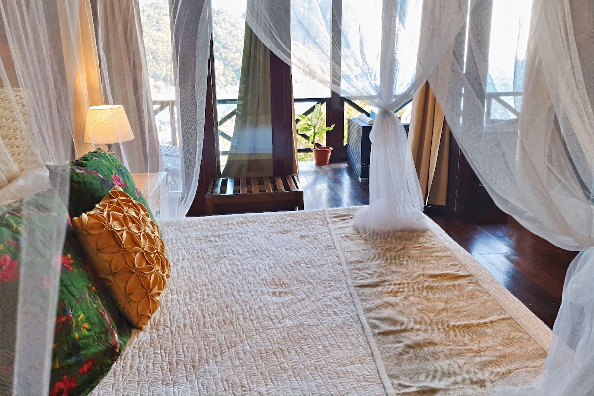 A bed with a white quilt, a green floral pillow, and a wooden headboard.