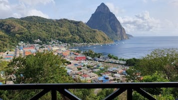 A coastal town with colorful buildings, a prominent mountain, and a clear view of the sea.