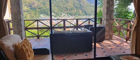 Un balcón con vistas a un paisaje montañoso y un pueblo en la falda.