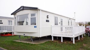 A mobile home with a deck, a nameplate, and a number plate. - Excellent Caravan 4 Birth Sleeps 6 Tranquil Site (Colchester)
