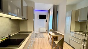 Une cuisine moderne équipée d’une cuisinière intégrée, d’un évier et d’un coin repas avec une table et des chaises.