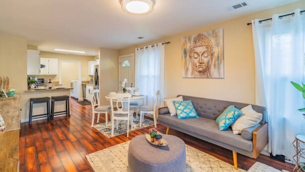Ein modernes Wohnzimmer mit einem grauen Sofa, einem runden Couchtisch und einem Buddha-Gemälde an der Wand.