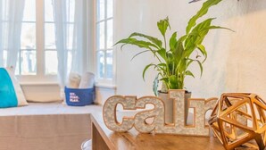 Ein hölzerner Empfangstresen mit einem Topfpflanzen, dekorativen Buchstaben, die „calm“ buchstabieren, und einer geometrischen Wanddekoration.